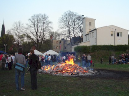 Das Osterfeuer schon etwas heruntergebrannt mit dem gerätehaus im Hintergrund