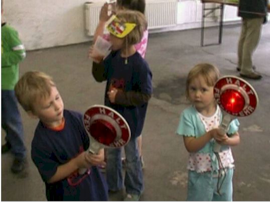 Kinder im Gerätehaus mit Feuerwehrkellen