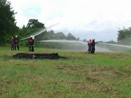 Feuerwehrmänner mit Löschschläuchen beim Löschangriff